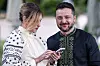 Volodymyr Zelenskyj og Olena Zelenska står sammen utendørs og ser på en mobiltelefon.