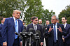 Donald Trump lytter til Jensen Huang foran Det hvite hus, omgitt av presse og andre politikere.