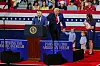 Donald Trump står på scenen med en familie under et arrangement om Trump-kontoer.